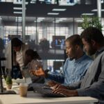 Black corporate team collaborate on global investment strategy, employing their extensive business expertise to work on data driven decisions. Solving administrative tasks for efficiency. Camera B.