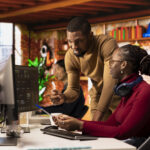 Teamworking startups employees leveraging machine learning technology in office to gain competitive edge. Silicon Valley company colleagues collaborating to do rapid technological advancement